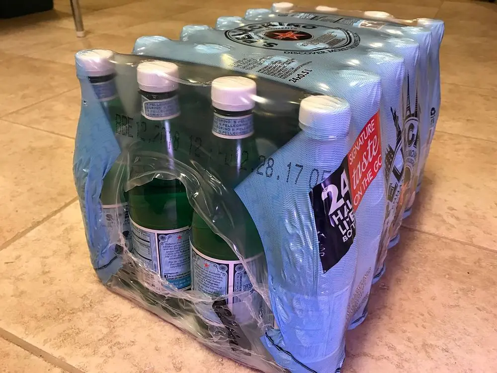 A 24-pack of water bottles bundled in clear shrink film with an open hole at the end.