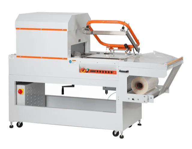 A white floor-standing machine with an orange L-shaped seal arm raised over a work table, a film roll on the right, and an enclosed shrink tunnel on the left.
