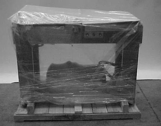 An L-bar sealer wrapped in stretch film and bolted to a wooden pallet.