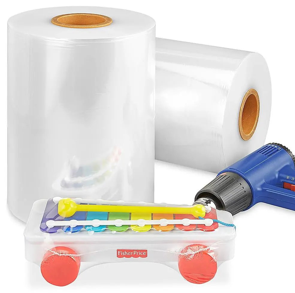 Two rolls of clear centerfold polyolefin shrink film and a toy shrink wrapped in the same film.